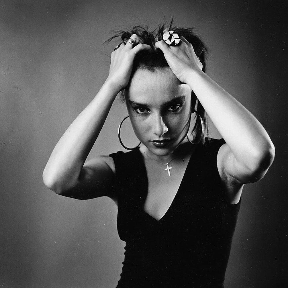 Portrait photographique noir blanc d'une jeune fille qui se tient les cheveux par Christian Rossier"